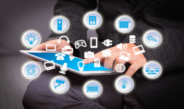 Hand touching a tablet surrounded by connected device icons